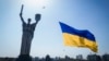 FILE - A drone carries a national flag in front of Ukraine's Motherland Monument in Kyiv, Ukraine, Aug. 24, 2022. 