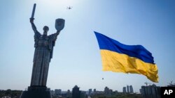 Un dron lleva una bandera nacional frente al Monumento a la Patria de Ucrania en Kiev, Ucrania, el 24 de agosto de 2022.