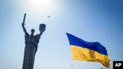 Un dron lleva una bandera nacional frente al Monumento a la Patria de Ucrania en Kyiv, Ucrania, el 24 de agosto de 2022.