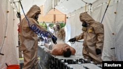 FILE - Members of the State Emergency Service attend nuclear disaster response drills amid shelling around the Zaporizhzhia Nuclear Power Plant, in Ukraine, Aug. 17, 2022.