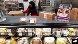 FILE - Madina Safi works in the bakery department at a grocery store in Alexandria, Va., April 14, 2022. She and her family were evacuated from Afghanistan and are trying to make a new life in the U.S.