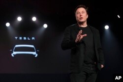 FILE - Tesla CEO Elon Musk speaks before unveiling the Model Y at the company's design studio, in Hawthorne, California, March 14, 2019.