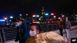 People brave strong wind on the promenade of Victoria Harbor as Tropical Storm Ma-On approaches Hong Kong, Aug. 24, 2022.