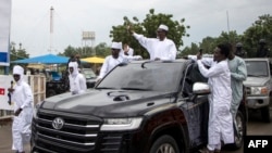 Timan Erdimi (C), leader of the rebel Union of Resistance Forces (UFR), waves as he leaves the N'Djamena International Airport after arriving in N'Djamena, Chad, Aug. 18, 2022, after years in exile.