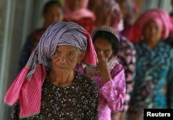 FILE - Women arrive at the entrance gate to the Extraordinary Chambers in the Courts of Cambodia (ECCC) for the trial hearing on evidences of forced marriage and rape during the Khmer Rouge regime, on the outskirts of Phnom Penh, Cambodia August 23, 2016.