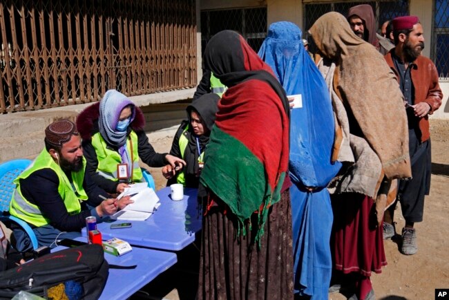FILE - Afghans register to receive food supplies during a distribution of humanitarian aid for families in need, in Kabul, Afghanistan, Feb. 16, 2022.