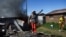 A resident gestures after the burning of shacks and belongings as mobs searched for alleged illegal miners in protest, following a gang rape of members of a video crew at a mine dump in the nearby township, in the West Rand, South Africa, Aug. 8, 2022.