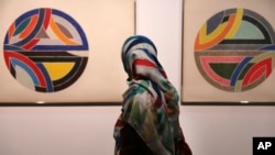 A visitor looks at artworks of the American artist Frank Stella, Sinjerli Variations No. 1-5- 1977, while visiting a 19th and 20th-century American and European minimalist and conceptual masterpieces show at the Tehran Museum of Contemporary Art in Tehran