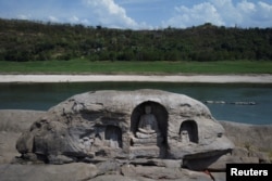 A once submerged Buddhist statue sits on top of Foyeliang island reef in the Yangtze river, which appeared after water levels fell due to a regional drought in Chongqing, China, August 20, 2022. (REUTERS/Thomas Peter)