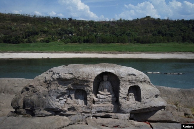 A once submerged Buddhist statue sits on top of Foyeliang island reef in the Yangtze river, which appeared after water levels fell due to a regional drought in Chongqing, China, August 20, 2022. (REUTERS/Thomas Peter)