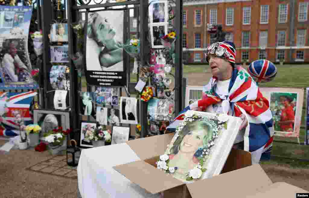 Royal fan John Loughrey shows off a cake with a picture of Princess Diana as he pays his respects to her, on the 25th anniversary of her death, outside Kensington Palace in London.