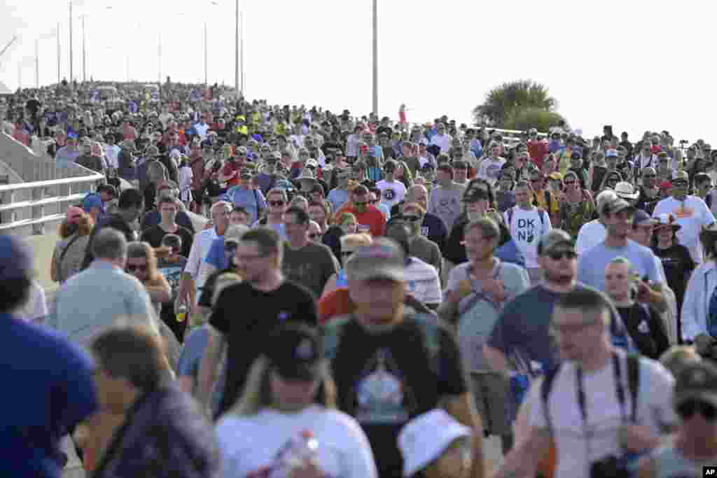 People leave the Max Brewer Bridge after a delay of the launch of the Artemis I mission to orbit the moon at the Kennedy Space Center in Titusville, Florida.