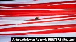 Bendera RI di tengah kibaran bendera merah putih saat merayakan HUT ke-77 di Pantai Losari, Makassar, Sulawesi Selatan, 17 Agustus 2022. (Foto: Antara/Abriawan Abhe via REUTERS)