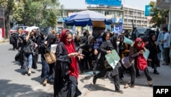 Taliban fighters fire into the air to disperse Afghan women protesters in Kabul on August 13, 2022. 