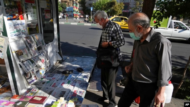 People scan publications at a news stand in Tehran, Iran, Aug. 13, 2022.