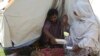 Rubina Bibi, right, sits near to her family after take refuge at a camp after fleeing her flood-hit homes, in Charsadda, Pakistan, Aug. 30, 2022.