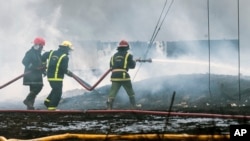 Los bomberos trabajan para apagar un incendio en una gran instalación de almacenamiento de petróleo en Matanzas, Cuba, el martes 9 de agosto de 2022. (Yamil Lage, vía AP)