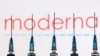 FILE - Syringes with needles are seen in front of a displayed Moderna logo in this illustration taken Nov. 27, 2021. 