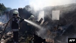 Ukrainian firefighters put out the fire in a destroyed house following a Russian shelling in the town of Bakhmut, Donetsk region, Aug. 24, 2022, amid Russia's invasion of Ukraine.