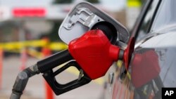 FILE - A motorist fills up the tank on a sedan, on July 22, 2022, in Saratoga, Wyo. 