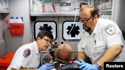Парамедики Джон Гарднер и Дэвид Фармер оказывают первую помощью мужчине, пострадавшему от передозировки, Салем, Массачусетс, 9 августа 2017 года