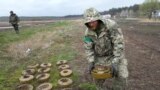 资料图：在乌克兰基辅近郊伊尔平的战斗后，一名工兵在雷区搜集地雷。(2022年4月19日)