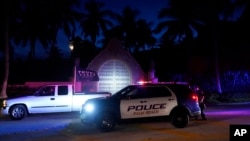 FILE - A supporter of former President Donald Trump drives past his Mar-a-Lago estate, Aug. 8, 2022, in Palm Beach, Florida, as the FBI conducts a search of the residence. 