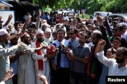 FILE - Supporters of Pakistan's former prime minister Imran Khan gather outside his home, in order to prevent his arrest on anti-terrorism charges, in Islamabad, Pakistan, Aug. 22, 2022.