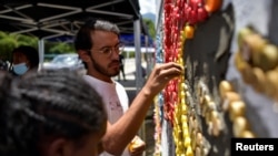 El artista venezolano Oscar Olivares usa tapas de botellas para crear un colorido mural ecológico para crear conciencia sobre el reciclaje, en Caracas, Venezuela, 19 de agosto de 2022. REUTERS/Gaby Oraa