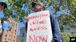 Seorang pria memegang poster bertuliskan permintaan untuk meningkatkan akses pemberian vaksin cacar monyet dalam aksi protes di San Francisco, pada 18 Juli 2022. (Foto: AP/Haven Daley)