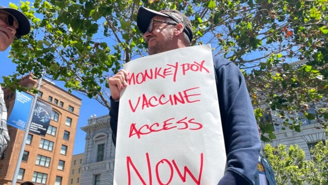 FILE - A man holds a sign urging increased access to the monkeypox vaccine during a protest in San Francisco, July 18, 2022.