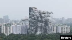 The Supertech Twin Towers collapses following a controlled demolition after the Supreme Court found them in violation of building norms, in Noida, India, Aug. 28, 2022. 