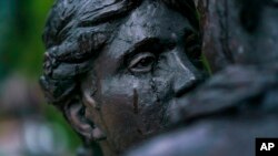 Raindrops fall down the face of a statue of a couple embracing in the city center, where many residents have evacuated from, in Druzhkivka, Donetsk region, eastern Ukraine, before a nightly curfew Aug. 18, 2022. 