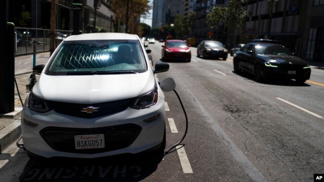 FILE - An electric vehicle is plugged into a charger in Los Angeles, Aug. 25, 2022.