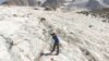 FILE - A glaciologist drills a hole at a measuring point on the Pers Glacier near the Alpine resort of Pontresina, Switzerland, July 21, 2022. 