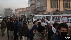 FILE - People queue to enter the passport office at a checkpoint in Kabul on Dec. 19, 2021, after Afghanistan's Taliban authorities said they would resume issuing passports.