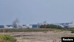 রাশিয়ার হামলার পরে গোলাবারুদের ধরণ নির্ধারণ করতে একজন ইউক্রেনীয় সেনা খারকিভের কিছু ক্ষতিগ্রস্ত বিল্ডিঙে গর্তের টুকরোগুলো সংগ্রহ করছেন। ৩০ আগস্ট, ২০২২।