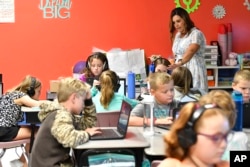 Angela Pike watches her fourth grade students at Lakewood Elementary School in Cecilia, Ky., as they use their laptops to participate in an emotional check-in at the start of the school day, Thursday, Aug.  11, 2022. (AP Photo/Timothy D. Easley)