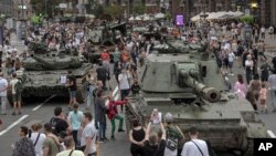 Ukrainians visit an avenue where destroyed Russian military vehicles have been displayed in Kyiv, Ukraine, Aug. 20, 2022.