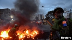 Los agentes de la policía antidisturbios intentan apagar una barricada iluminada por los manifestantes tras el anuncio de los resultados de las elecciones presidenciales de Kenia, cerca de los barrios marginales de Mathare, el 15 de agosto de 2022.