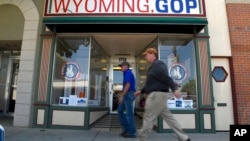 Two men walk in front of the Wyoming Republican Party headquarters in Cheyenne, Wyo., July 19, 2022. Rep. Liz Cheney, Wyoming's congresswoman since 2016, is facing a Donald Trump-backed opponent, attorney Harriet Hageman, in the state's upcoming Republican primary.
