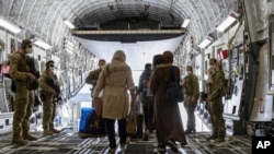 In this image provided by the Australian Defense Force, Aug. 22, 2021, Afghanistan evacuees arrive at Australia's main operating base in the Middle East, on board a Royal Australian Air Force C-17A Globemaster. (LACW Jacqueline Forrester/Australian Defens