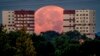 The full moon sets behind apartment houses in the outskirts of Frankfurt, Germany. 