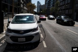 An electric vehicle is plugged into a charger in Los Angeles, Thursday, Aug. 25, 2022. (AP Photo/Jae C. Hong)