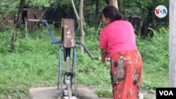 Una señora recoge agua en un pozo en una comunidad en el departamento de León. Foto VOA