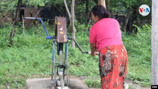 Una señora recoge agua en un pozo en una comunidad en el departamento de León. Foto VOA