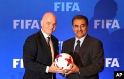 Presiden FIFA Gianni Infantino (kiri), memegang bola bersama Presiden Federasi Sepak Bola Seluruh India (AIFF) Praful Patel saat konferensi pers di Kolkata, India, Jumat, 27 September 2017. (AP)