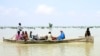 Pakistani men use a boat to salvage usable items from their flood-hit homes in Sindh Province in southern Pakistan, Aug. 27, 2022. 