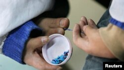 FILE - A disabled worker makes handicrafts at the Sweet Home factory in Shanghai Dec. 4, 2008.