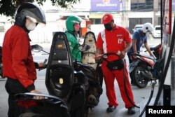 Pekerja SPBU Pertamina mengisi sepeda motor dengan bensin bersubsidi di Jakarta, 22 Agustus 2022. (REUTERS/Ajeng Dinar Ulfiana)